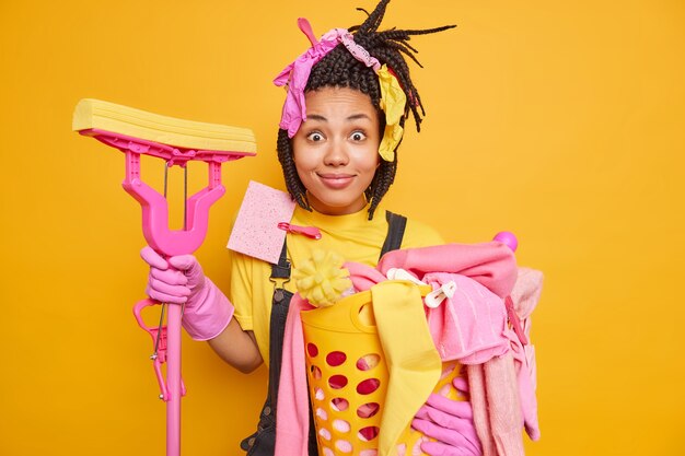 Positivo surpreso, dona de casa ocupada, lavando roupa e limpando a casa