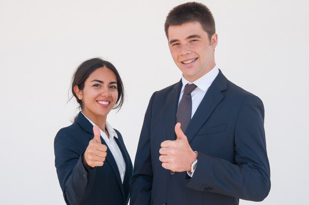 Positivos colegas de trabalho confiante, mostrando os polegares para cima