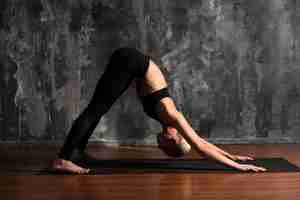 Foto grátis postura completa da ioga da mulher na esteira