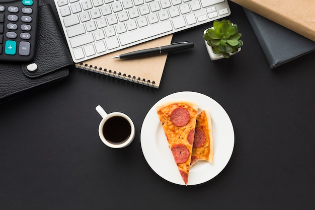 Postura plana da área de trabalho com teclado e pizza