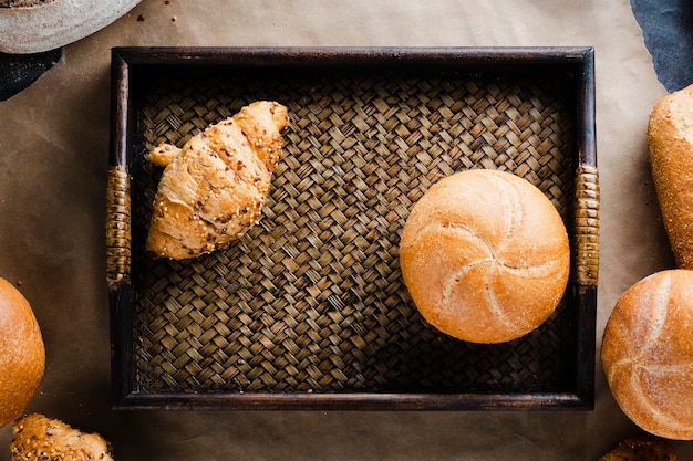 Postura plana de croissant e pão em uma cesta