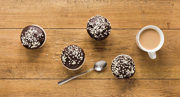 Postura plana de donuts na superfície de madeira com café e colher