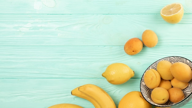 Postura plana de frutas em fundo de madeira com espaço de cópia