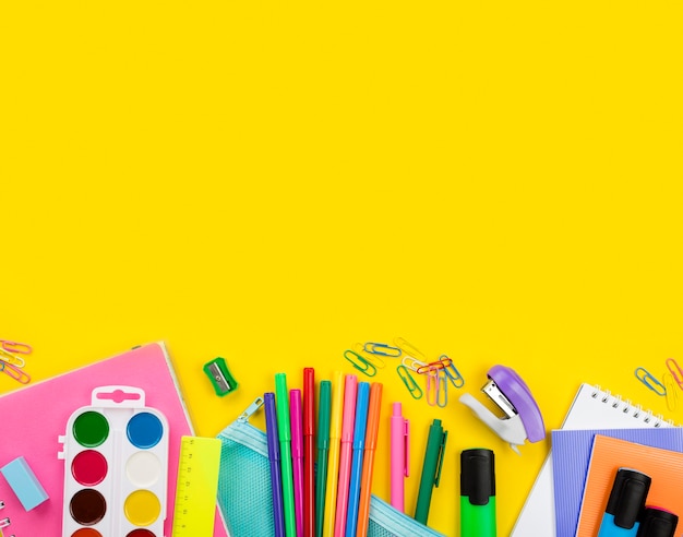 Postura plana de itens essenciais da escola com lápis e aquarela