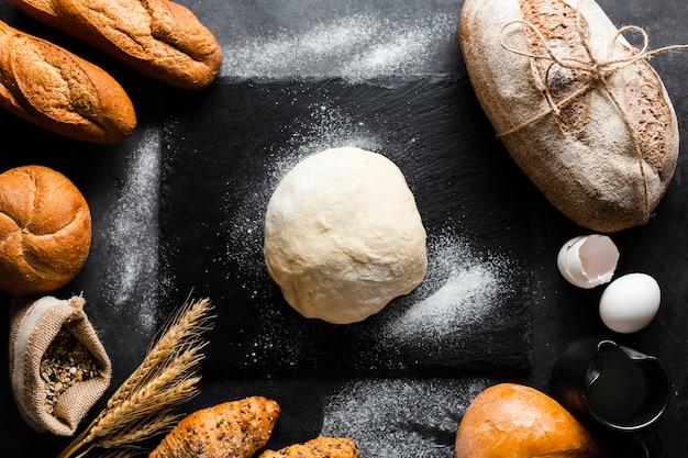 Postura plana de massa e pão em fundo preto