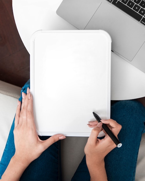 Postura plana de mulher segurando o quadro branco com caneta