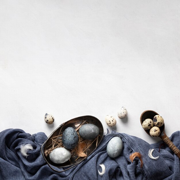 Foto grátis postura plana de ovos de páscoa com espaço de cópia e têxteis