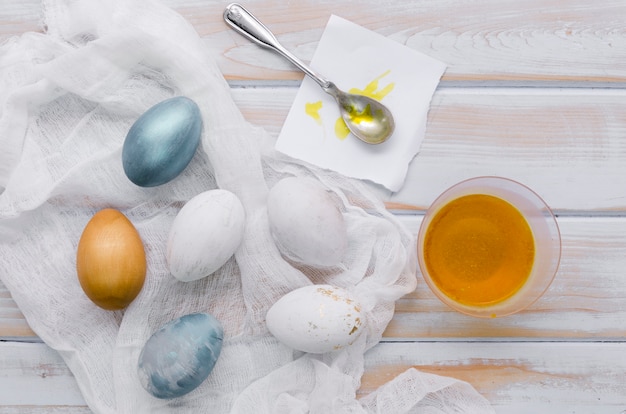Postura plana de ovos pintados para a Páscoa com corante e colher
