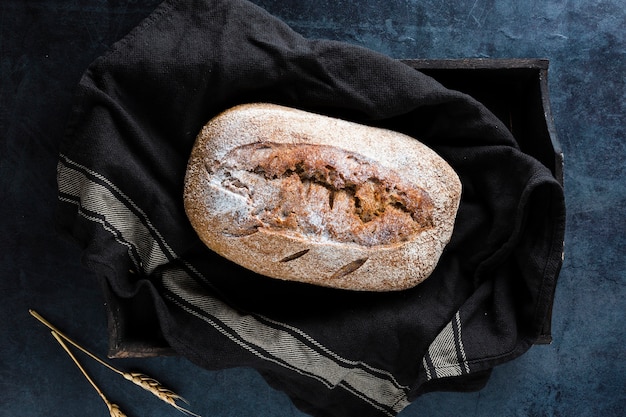 Foto grátis postura plana de pão no pano preto