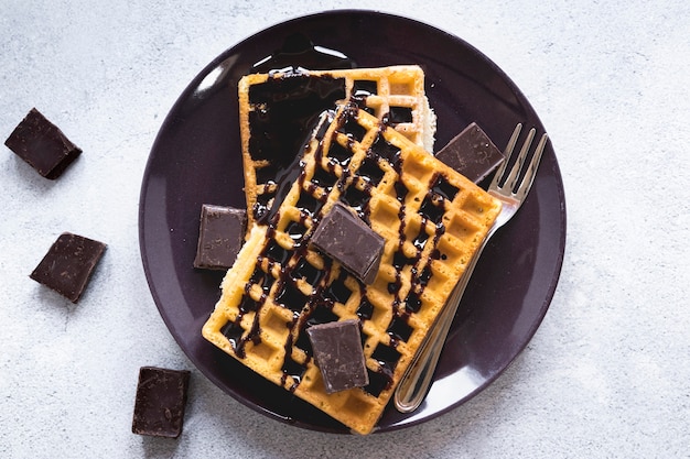 Postura plana de prato com waffles e chocolate