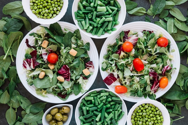 Foto grátis postura plana de pratos com saladas e feijão verde