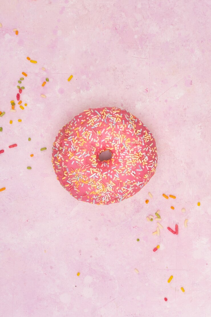 Foto grátis postura plana de rosquinha vitrificada colorida com granulado