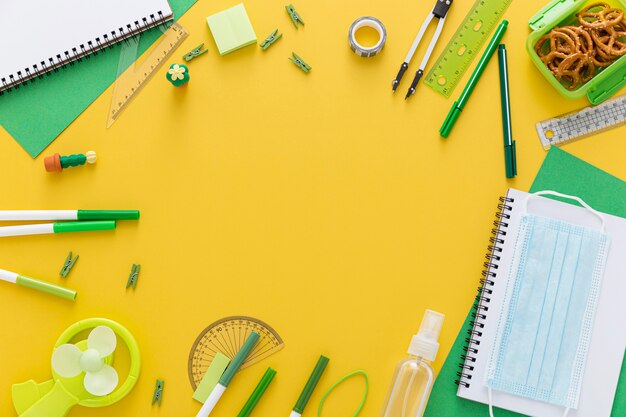 Postura plana de volta aos materiais escolares com caderno e máscara facial