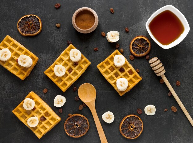 Foto grátis postura plana de waffles com banana e frutas cítricas secas