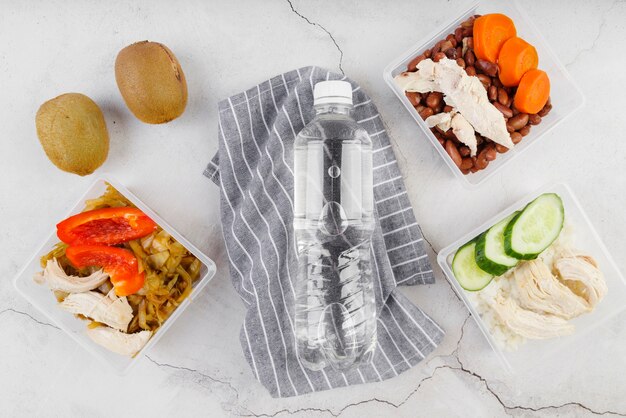 Postura plana do conceito de comida com garrafa de água