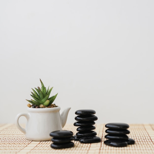 Foto grátis pot ao lado de três pilhas de pedras