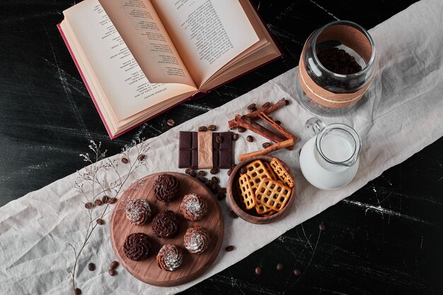 Pote de leite com grãos de café e bombons de chocolate.