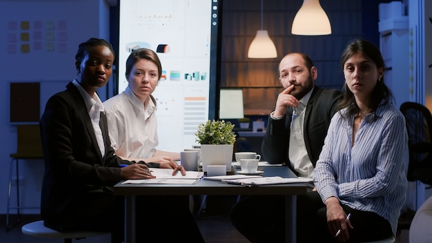 Pov de diversos empresários multiétnicos sentados à mesa de conferências discutindo a estratégia da empresa