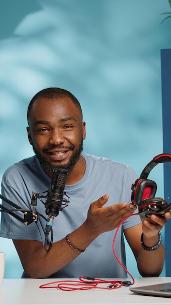 Foto grátis pov do influenciador revisando fones de ouvido na câmera para o canal de vlog. vlogger fazendo review de produto de headset para música e sons, filmando para redes sociais e dando recomendações.