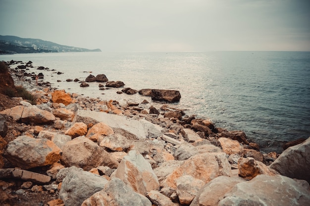 Praia rochosa em um dia nublado perto do mar negro, crimeia Foto Premium