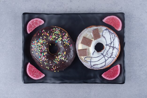 Prato com donuts e marmeladas em superfície de mármore