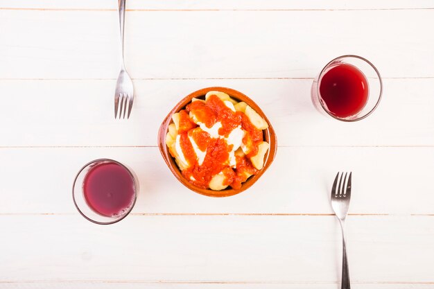 Foto grátis prato com garfos e bebidas na mesa