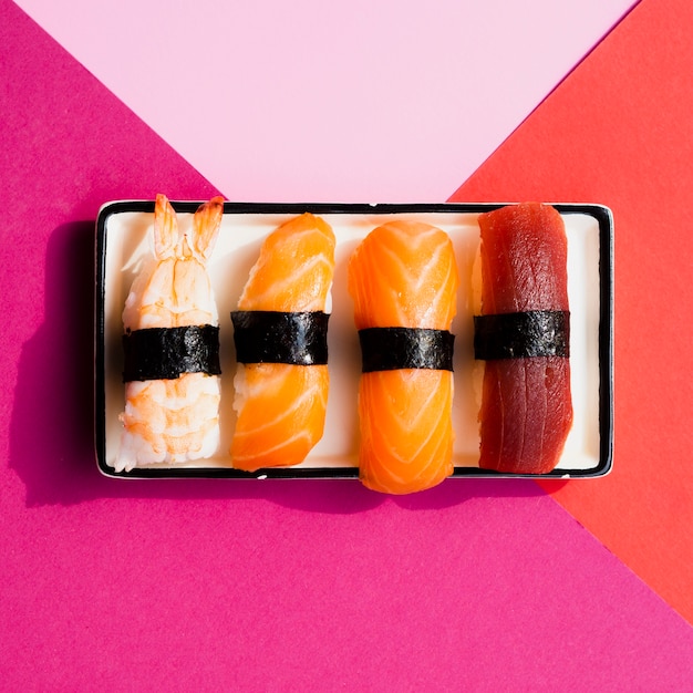 Foto grátis prato com sushi em um fundo rosa e vermelho