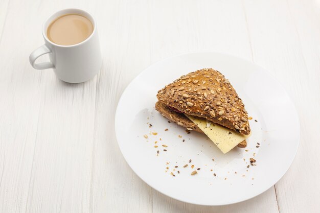 Prato com um sanduíche e uma xícara de café