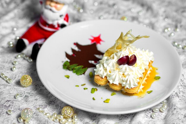 Prato de biscoitos com creme ao lado da árvore de Natal em pó de café