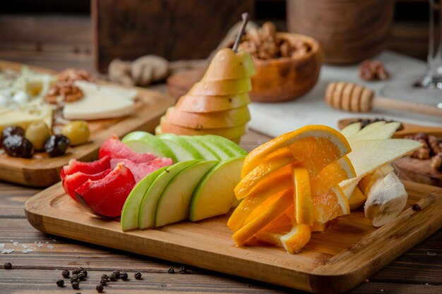 Foto grátis prato de frutas com fatias de maçã, banana, ameixa e laranja