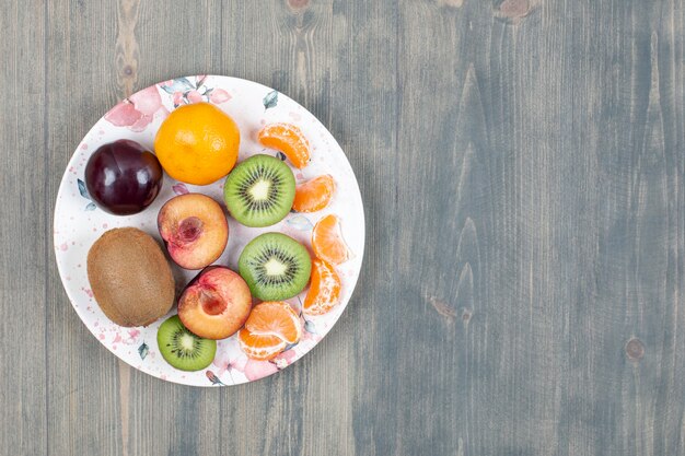 Prato de frutas fatiadas em superfície de madeira