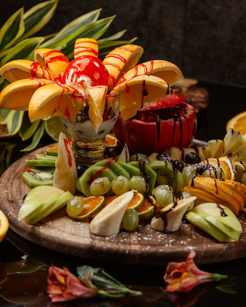 Foto grátis prato de frutas frescas com sorvete no molho vermelho por cima