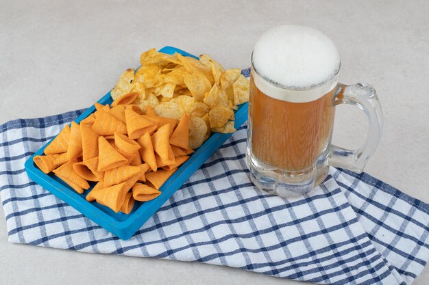 Prato de lanche e copo de cerveja na toalha de mesa