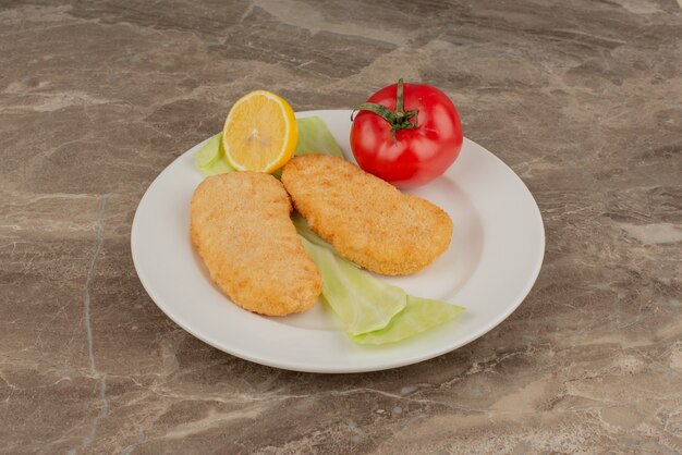 Prato de nuggets de tomate, limão e frango.