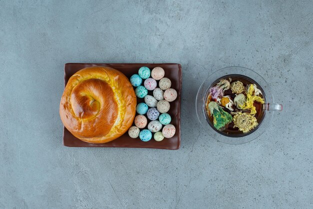 Prato de pastelaria e doces com xícara de chá no mármore.