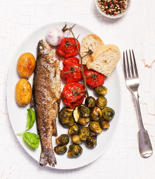 prato de peixe cozido com legumes e pão