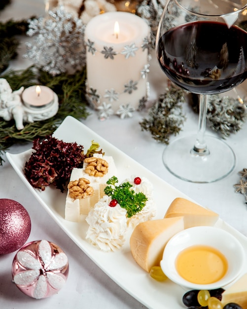 Prato de queijo com nozes e taça de vinho