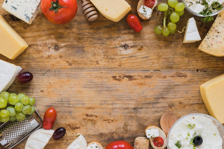 Foto grátis prato de queijo com tomate, uvas e mini sanduãches na mesa de madeira com espaã§o para escrever o texto