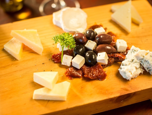 Foto grátis prato de queijo com um copo de vinho tinto