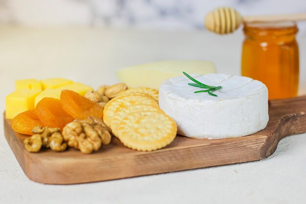 Prato de queijo, queijo camembert, alecrim, bolachas, damasco seco e nozes