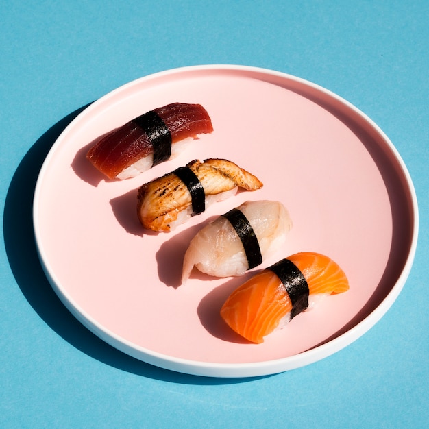 Foto grátis prato de rosa com sushi em fundo azul