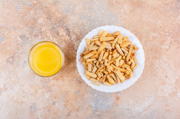 Prato de saborosos biscoitos crocantes e copo de suco no fundo de mármore. Foto de alta qualidade