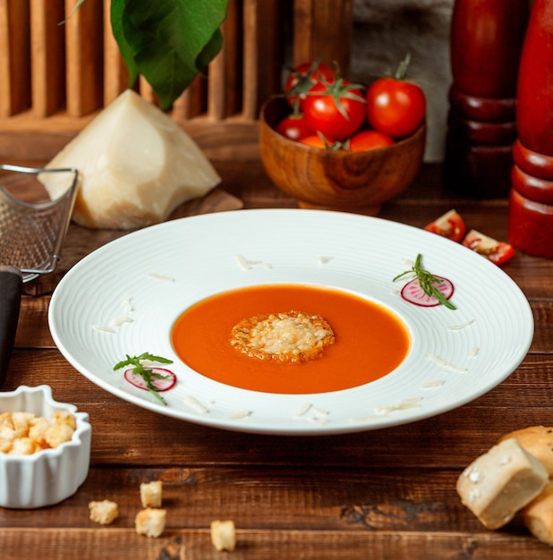 Prato de sopa de tomate, guarnecido com parmesão ralado na tigela de sopa