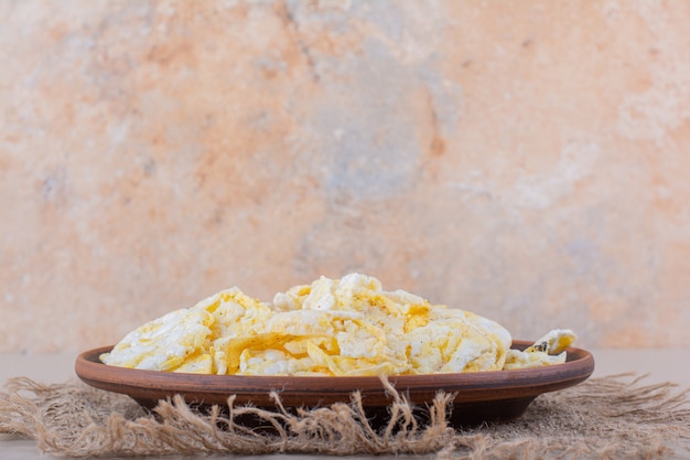 Prato marrom de chips de arroz crocante na mesa branca