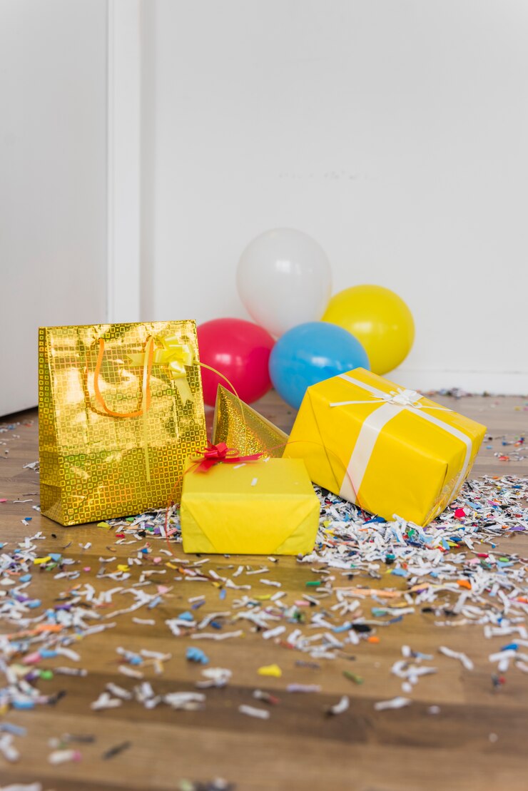 Foto grátis presentes; balões e chapéu de festa com confete no assoalho de folhosa