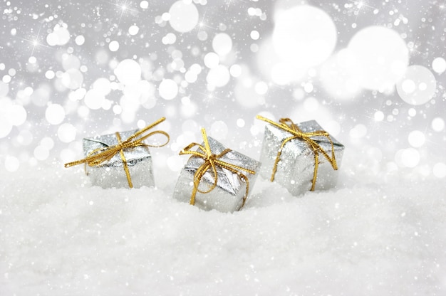 Presentes de Natal de prata aninhado na neve