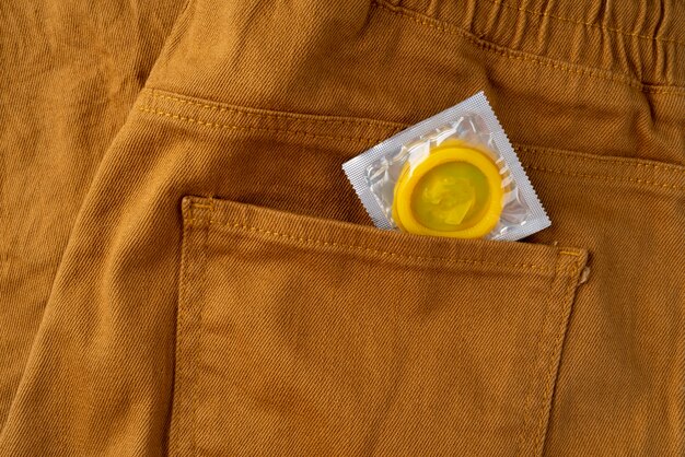 Preservativo amarelo e jeans