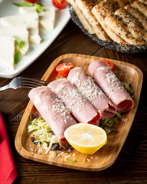 Foto grátis presunto enrolado em um rolo e polvilhado com parmesão ralado