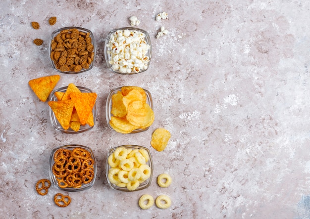 Pretzels, batatas fritas, biscoitos e pipoca em tigelas