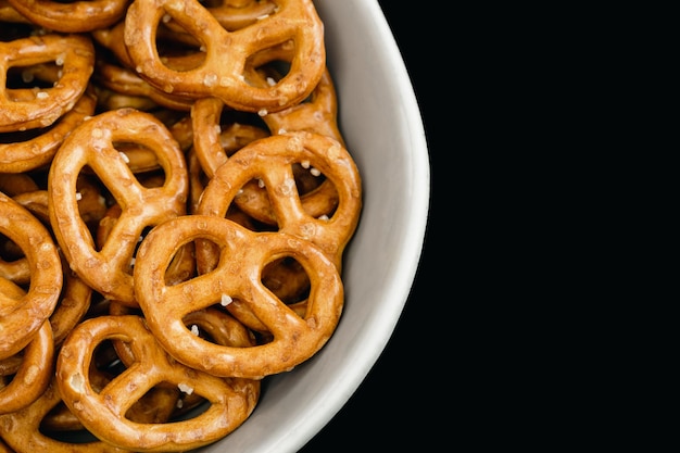 Pretzels closeup em um prato em um fundo preto